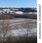North Saskatchewan river valley field winter landscape with hay bales