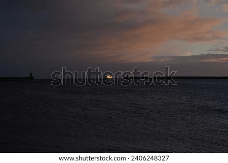 North Sea ferry entering the mouth of the River Tyne at sunrise on winter morning, North East England.