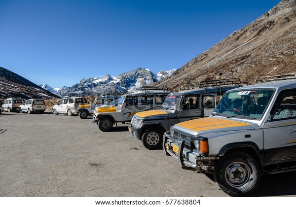NORTH SIKKIM, INDIA -\
DECEMBER 29, 2015: Four wheel drive cars parking area with Yunthang\
Valley in the background in winter in Zero Point at Lachung. North\
Sikkim, India.
