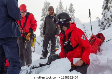 North Vancouver, British Columbia, Canada - February 17, 2020: North Shore Search And Rescue Are Rescuing A Man Skier With A Broken Leg In The Backcountry Of Seymour Mountain During Winter Evening.