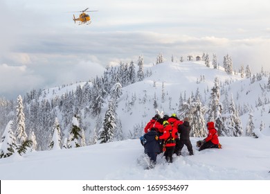 North Vancouver, British Columbia, Canada - Feb 17, 2020: North Shore Search And Rescue Are Rescuing A Man Skier With A Broken Leg In The Backcountry Of Seymour Mountain With A Helicopter In Winter.