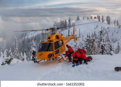 North Vancouver, British Columbia, Canada - Feb 17, 2020: North Shore Search And Rescue Are Rescuing A Man Skier With A Broken Leg In The Backcountry Of Seymour Mountain With A Helicopter In Winter.