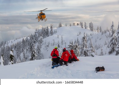 North Vancouver, British Columbia, Canada - Feb 17, 2020: North Shore Search And Rescue Are Rescuing A Man Skier With A Broken Leg In The Backcountry Of Seymour Mountain With A Helicopter In Winter.