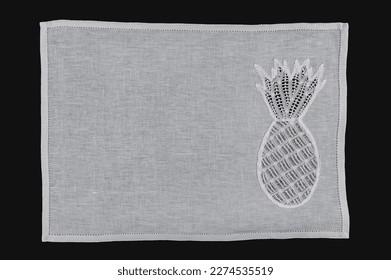 Northeast Brazilian Renaissance lace placemat, with an embroidered pineapple, isolated on black background.