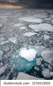 Northern Arctic Ice Floes Are Seen Breaking Up And Melting Leading Into An Atmospheric Moody Horizon.Climate Crisis And  Global Warming.Vertical Image