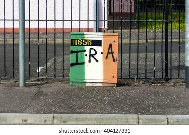 Northern Ireland, Londonderry: Street Scene With IRA Graffiti On An Electricity Power Box With Fence And House In The City Center Of The Town. June 23, 2015