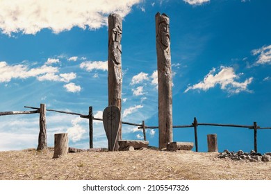 Northern Lands. A Pagan Temple In The Taiga With Two Wooden Idols. The Image Of Pagan Gods Is Carved On Wooden Logs.