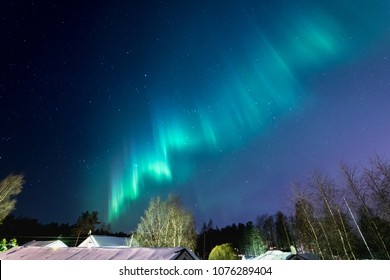 Northern Lights (Aurora Borealis) On Night Sky Above House Roofs At Countryside, North Of Sweden, Village