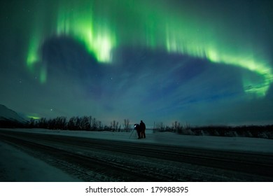 Northern Lights (Aurora Borealis) In Sweden Above A People On A Road