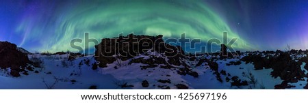 Northern Lights bursting above an Arctic rocky landscape