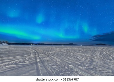 Northern lights glow above a frozen lake in Lapland - Powered by Shutterstock