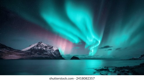 Northern Lights over the sea, snowy mountains at starry winter night. Aurora borealis in Lofoten islands, Norway. Sky with polar lights. Landscape with aurora, beach, sky, reflection in water. Space - Powered by Shutterstock