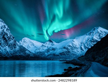 Northern lights over the snowy mountains, frozen sea, reflection in water at winter night in Lofoten, Norway. Aurora borealis and snowy rocks. Landscape with polar lights, road, starry sky and fjord - Powered by Shutterstock