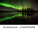 Northern lights and it´s reflection in the lake in Kuusamo, Finland