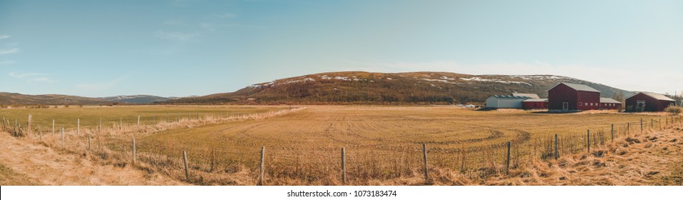 Northern Norway On A Summer Day, A Field And Some Buildings