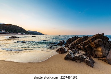 Northern side of Jeongdongjin sandy beach and its rocks at sunset, Gangneung, Gangwon-do,South Korea.