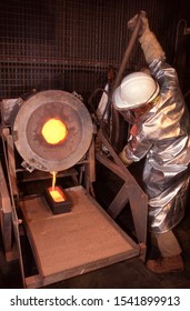 Northern Territory, Australia: June 4, 2003: View Of Gold Mine Worker Wearing Heat Protective Clothing Pouring Molten Gold Into An Ingot Mold