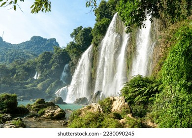 Northern Vietnam, the famous Ban Gioc Waterfall. Situated on the Vietnamese - Chinese boarder. A  couple walks near the falls. - Powered by Shutterstock