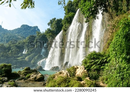 Northern Vietnam, the famous Ban Gioc Waterfall. Situated on the Vietnamese - Chinese boarder. A  couple walks near the falls.