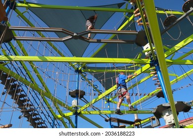 Northglenn, CO USA - August 22, 2021: Boondock's Food And Fun Center Amusement Park. Looking Up At A Colorful Outdoor Ropes Course. People With Harnesses And Obstacles        