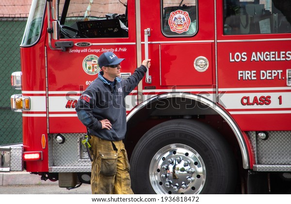 Northridge, California,\
USA -  March 8, 2021: LAFD firefighters and paramedics respond to a\
medical call at Northridge train station, an ambulance and a fire\
engine are\
pictured.