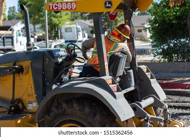 Northridge, California / USA -  September 25, 2019: L.A. Road Construction Crew John Deer Tractor Operator Examining Work While Resurfacing Road And Pavement In Northridge.