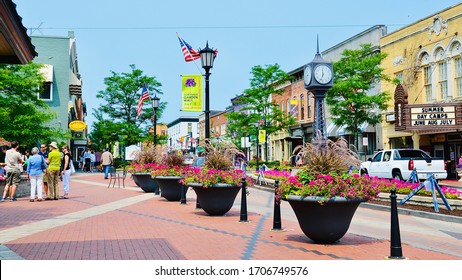 Northville, MI, US - July 3, 2015: Beautiful summer at the town square. A traditional small town in US: clean street, colorful gardening flowers, people walking and greeting on the holiday weekend.