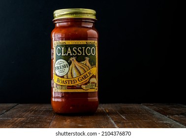 NORWALK, CT, USA - JANUARY 10, 2022:   Classico Roasted Garlic Pasta Sauce In Jar On Wooden Boards With Black Background Behind