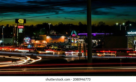 NORWALK, CT, USA -  NOVEMBER 24, 2021: Sunset over busy  Route 1 or Connecticut Avenue with trail lights and advertising store signs day before Thanksgiving Day