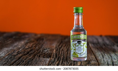 NORWALK,CT, USA - DECEMBER 8, 2021:  Smirnoff Green Apple Vodka Small Bottle On Wooden Rustic Table With Orange Background