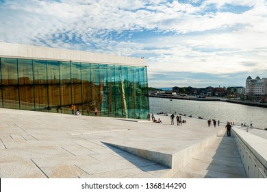 Norway, Oslo August 1, 2013: Tourists Take Photos And Admire The View Of The Oslo Panorama From The Embankment Of The Opera House At Sunset.