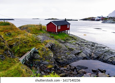 Norwegian coast landscape with a typical red house. Wooden red houses are called rorbu or rorbuer and are used for fishermen or tourists. Lofoten, Norway