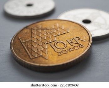 Norwegian coins lie on gray surface. 10 Norges kroner coin close-up. National currency of Norway. News about economy or finance. Bank and loan. Savings and interest. Krone and Norges Bank. Macro
