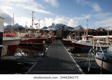 Norwegian fishing boats and ships docked in a small marina.  Small island fishing town of Husøy on Senja, Norway.  A fishing village located in the Arctic Circle of Northern Norway.  - Powered by Shutterstock