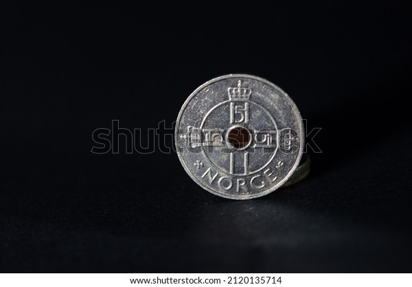 Norwegian\
metal coin with denomination of one Norwegian krone,Norwegian krone\
coins in a black background,Norwegian metal coin with denomination\
of one Norwegian krone, five Norwegian\
kroner