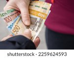 Norwegian money passing from hand to hand, Giving Norwegian kroner, Cash payment, Financial flow, Business concept