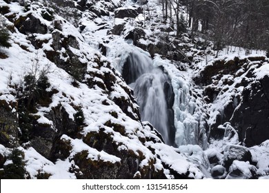 Norwegian Waterfall Down Snowy Mountian