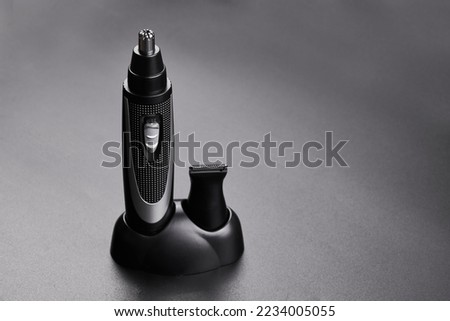 Nose and ear hair removal trimmer, men's electric razor close-up isolated on black background