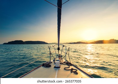 Nose of yacht sailing in the sea at sunset
