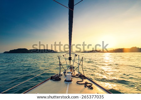 Nose of yacht sailing in the sea at sunset