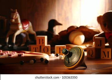 Nostalgic Antique Wooden Spinning Top Play Time Toy And Traditional Collection Of Old Wood Children Toys With Baseball Glove And Teddy Bear With Vintage Alphabet Blocks And Marbles In An Attic