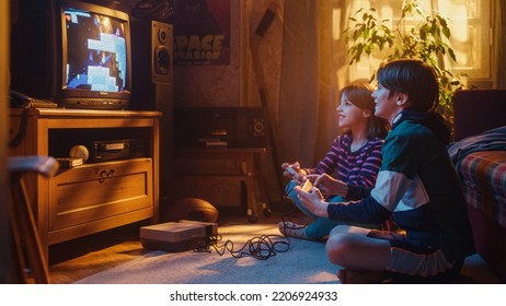 Nostalgic Childhood Concept. Young Brother And Sister Playing Old-School Arcade Video Game On Retro TV Set In A Living Room With Period-Correct Interior. Friends Spend The Day At Home Playing Games.