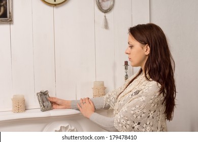 Nostalgic Elegant Young Woman Looking At An Old Family Portrait As She Pays Tribute To A Deceased Loved One And Reminisces About The Past