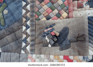 Nostalgic handmade patchwork quilt detail with applique and decorative stitchwork. This close up view of cozy, crafty textile art shows various fabric patterns and textures