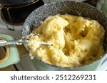 nostalgic kitchen scene featuring a pot of creamy mashed potatoes, accompanied by a perforated metal masher, evokes warmth and comfort celebration of homemade meals