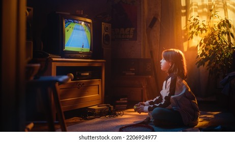 Nostalgic Retro Childhood Concept. Little Girl Watches A Tennis Match On TV In Her Room With Dated Interior. Supporting Her Favorite Player, Getting Excited While Watching An Important Game.