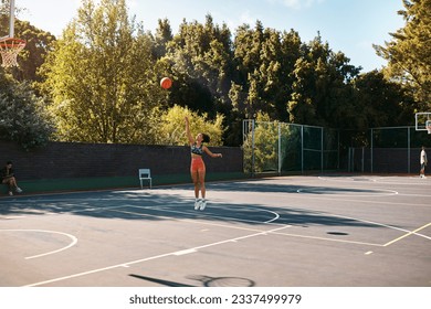 Its not about how good you are, its how good you want to be. Shot of a sporty young woman throwing a basketball into a net on a sports court.