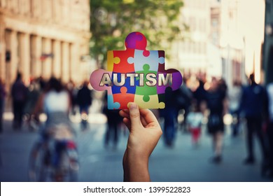 I am not alone symbol of Autism as a child hand holding a colorful puzzle piece over a crowded street background. Social awareness, autistic education development. Jigsaw fragments connected together. - Powered by Shutterstock