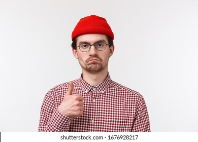 Not Bad, Really Good Job. Close-up Portrait Satisfied Serious-looking Bearded Young Man In Beanie And Glasses Make Judgement, Show Thumb-up In Approval Or Like Gesture, White Background