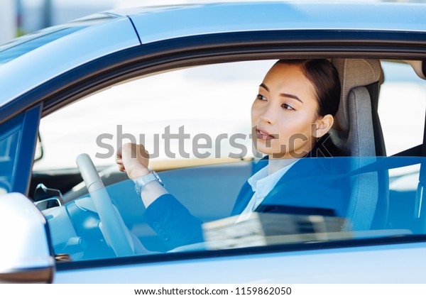 Not to be late. Smart nice woman looking at the
time while driving in the
car